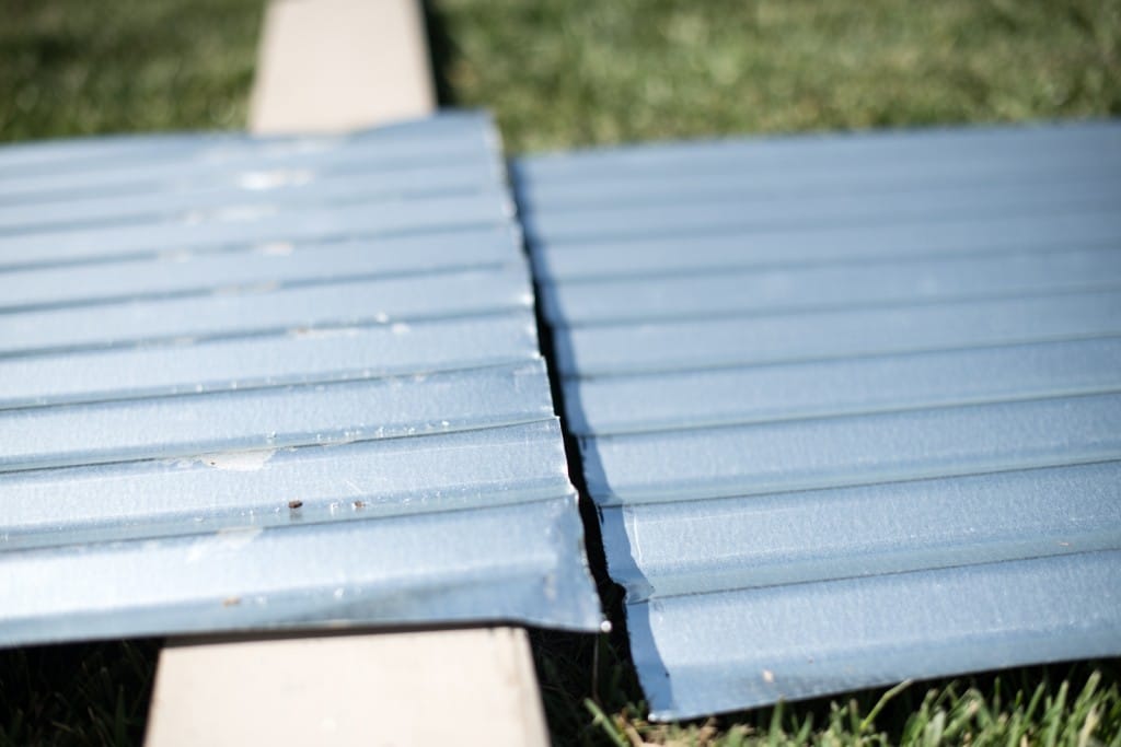 Cut corrugated metal panels ready to be screwed back together into garden bed form