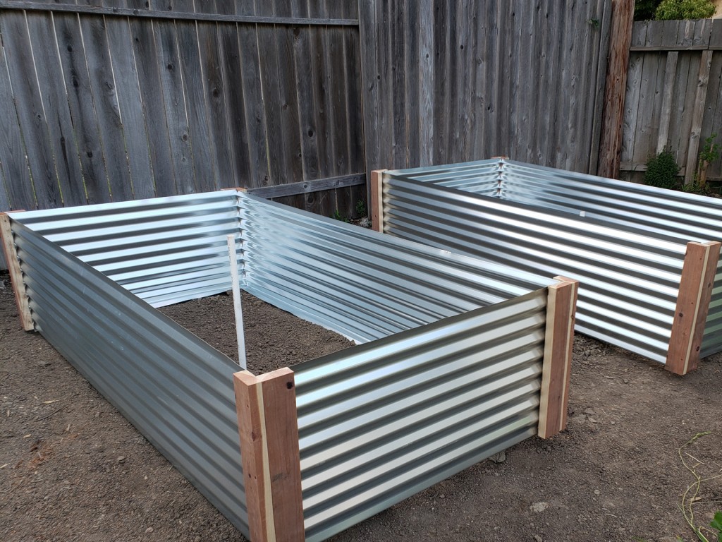 Positioning each raised metal garden bed over its spot and eyeballing the layout