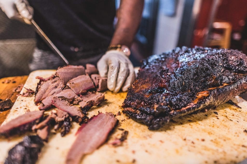 Oakland food scene everett and jones barbeque cutting meat