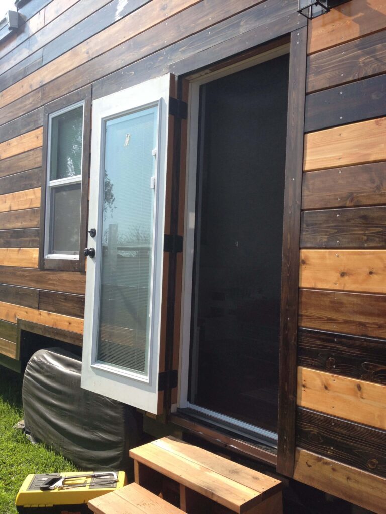 Retractable screen door in tiny house for passive cooling.