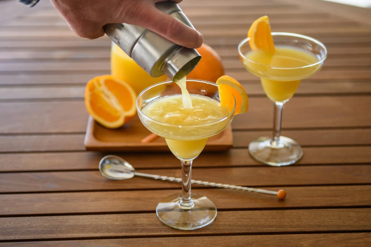 Orange creamsicle cocktail drink pouring