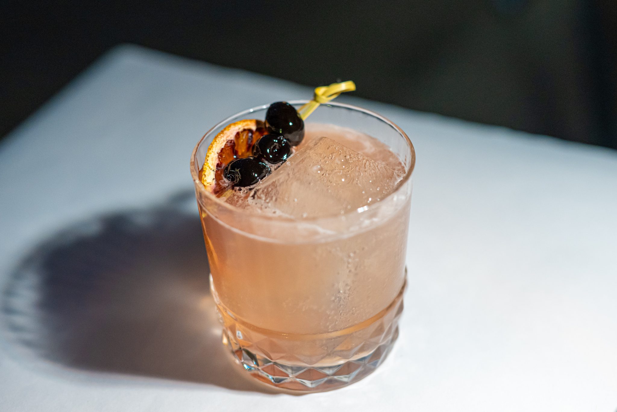 Craft cocktail over a large ice cube at a sacramento bar