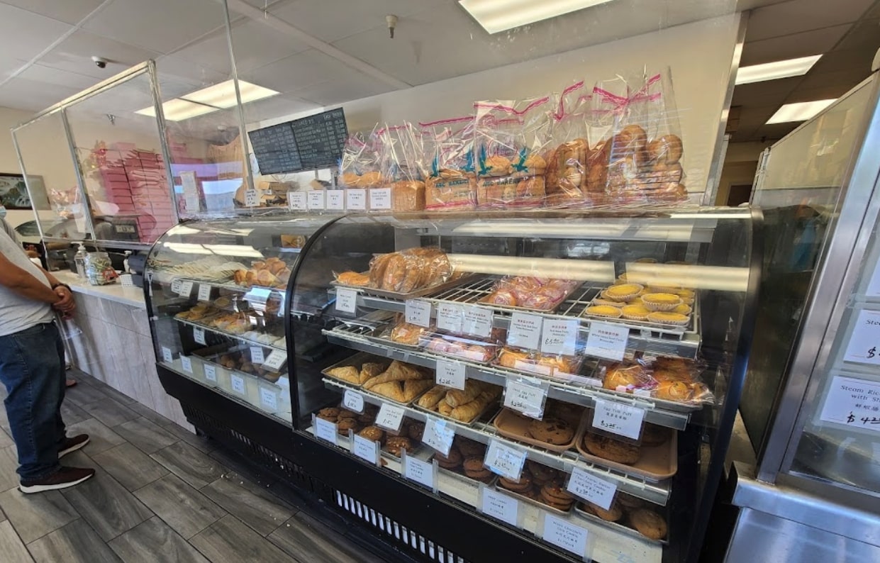 Bakery case of dim sum buns, egg tarts, and pastries at abc bakery in sacramento