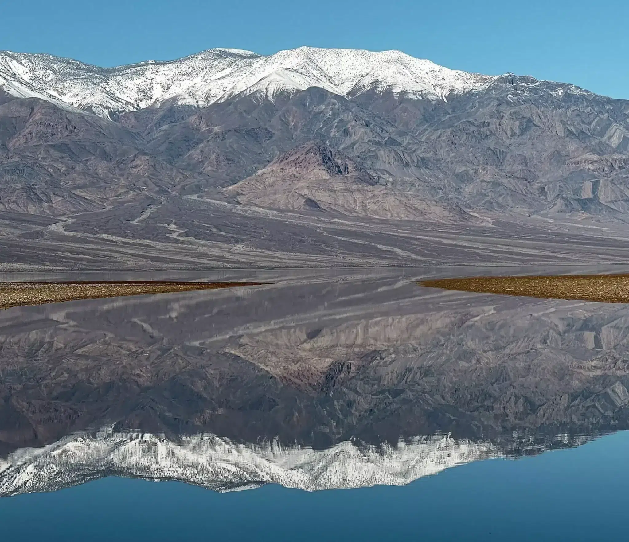 Visiting lake manly in badwater basin death valley national park mountains reflecting in lake