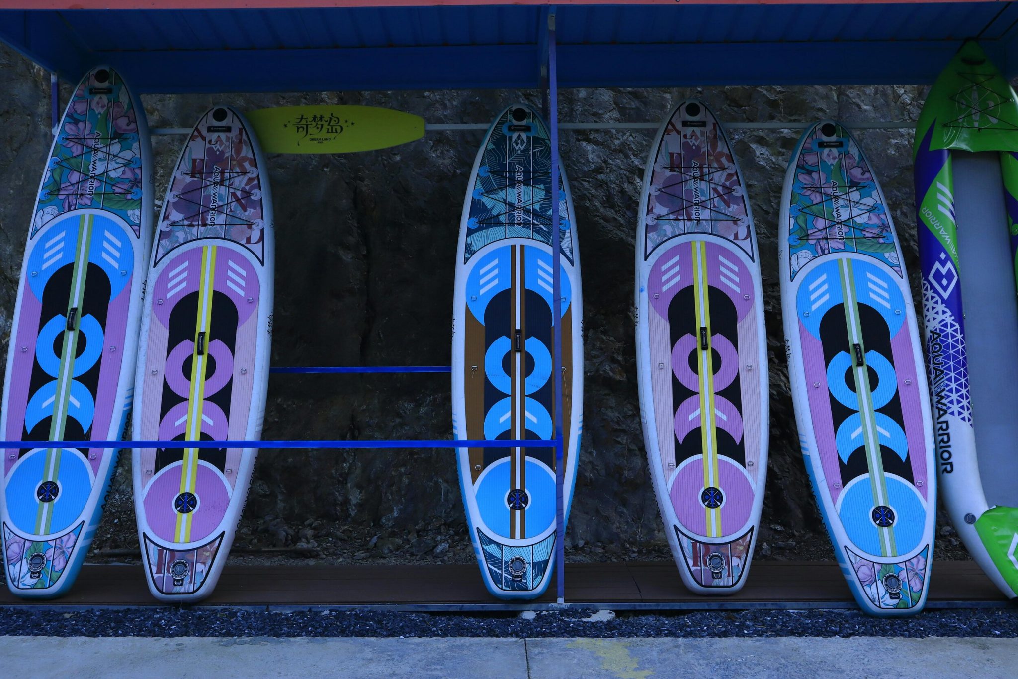 Colorful stand-up paddleboards lined up outdoors