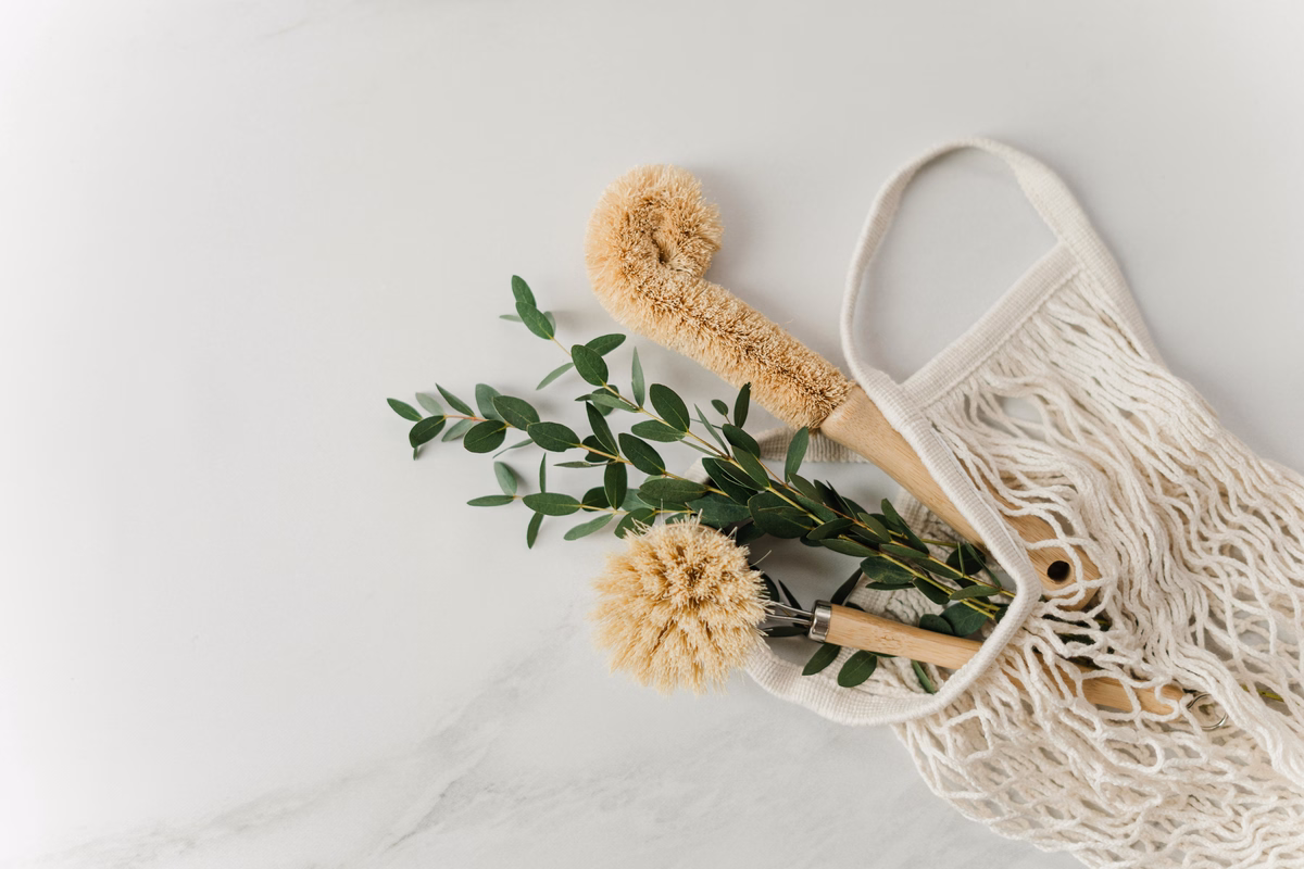 Eco-friendly cleaning brushes and natural supplies in a reusable net bag