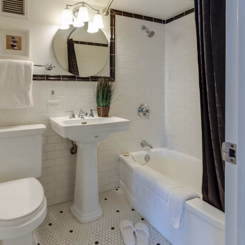 White subway tile bathroom with bathtub drain that was unclogged using enzyme drain cleaner