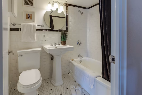 White subway tile bathroom with bathtub drain that was unclogged using enzyme drain cleaner
