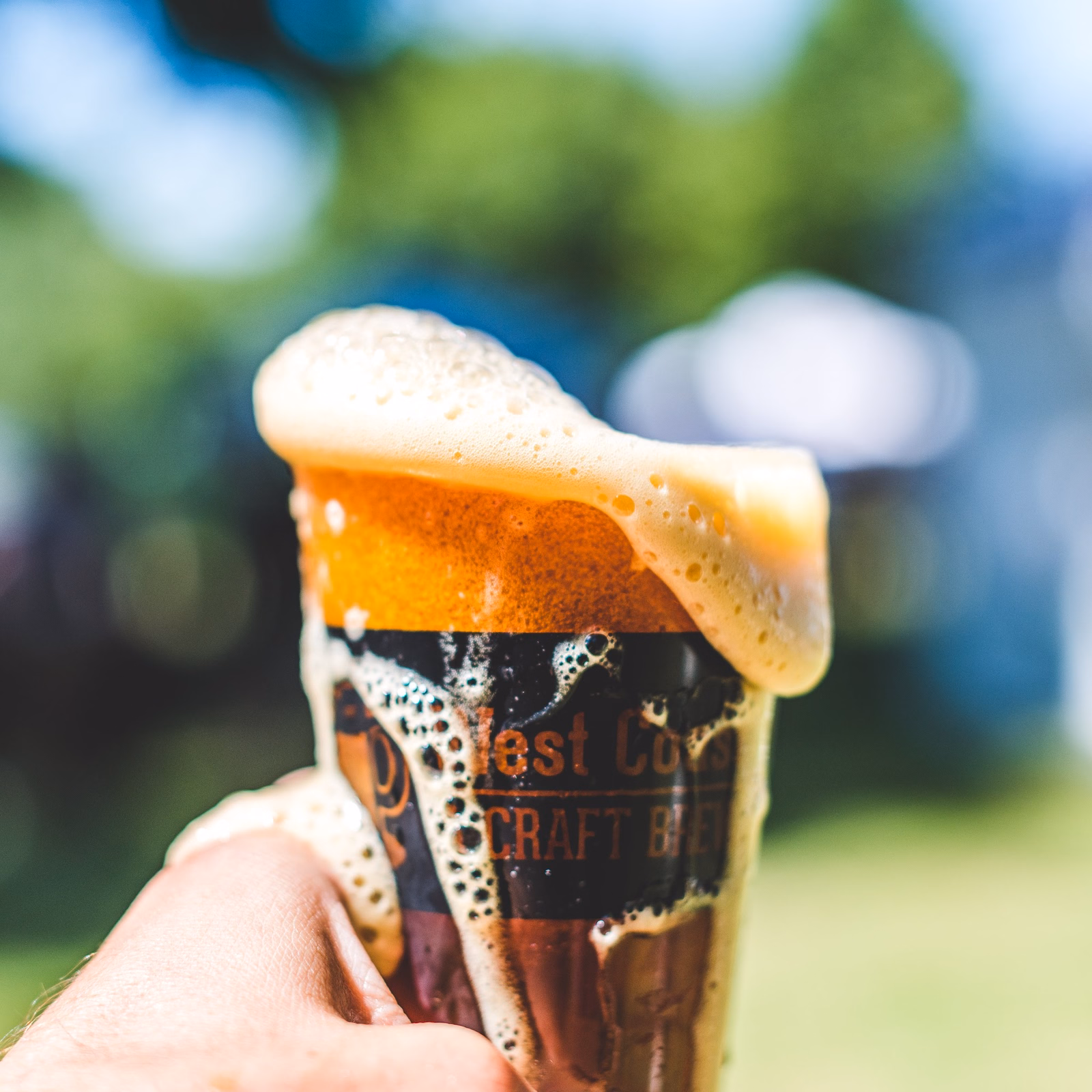 Overflowing craft beer pint with foam at a sacramento beer week festival pour