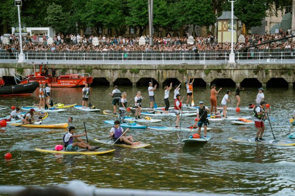 Homepage 11 explore sacramento Stand-up paddleboarders gathering on an urban river for a race event with spectators along the embankment