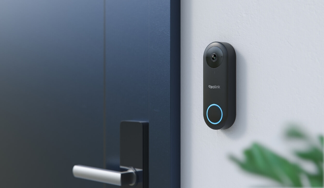 Reolink video doorbell wifi mounted on a wall beside a dark blue front door