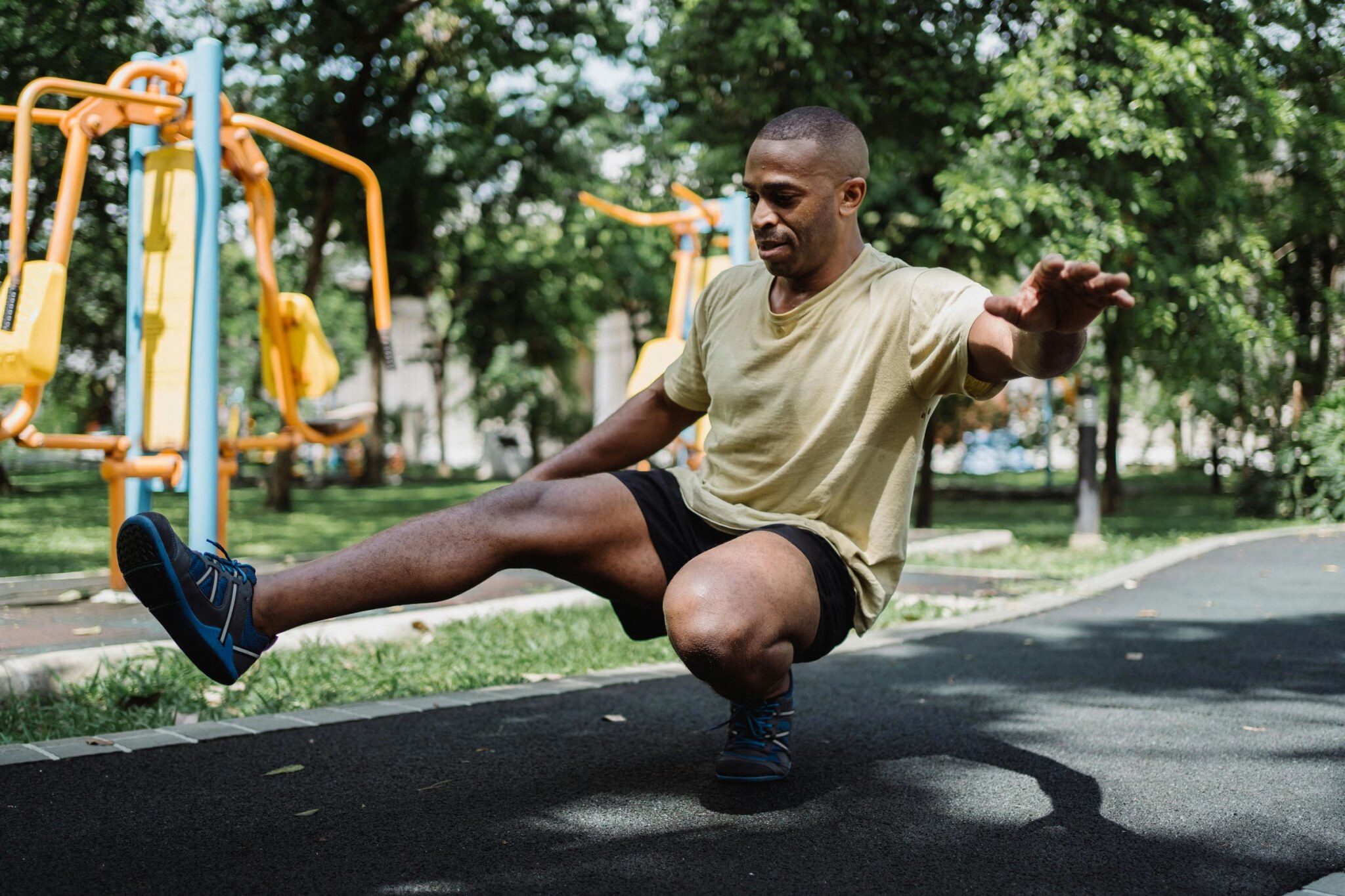 Athlete performing a single-leg balance exercise in an outdoor park, training for paddle board stability