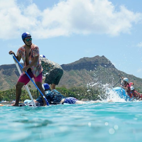 Stand-up paddle boarders racing on flatwater off honolulu with diamond head in the background