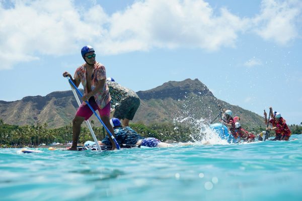 Stand-up paddle boarders racing on flatwater off honolulu with diamond head in the background