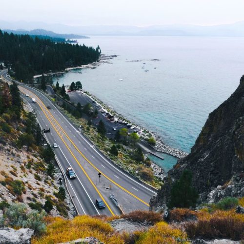 Highway winding along the forested shoreline of lake tahoe on a day trip from sacramento