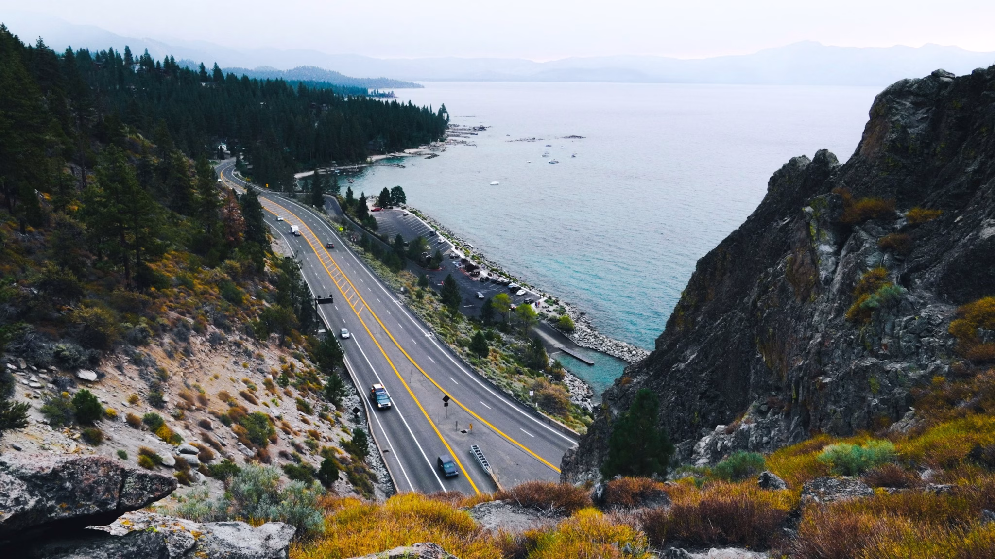 Highway winding along the forested shoreline of lake tahoe on a day trip from sacramento