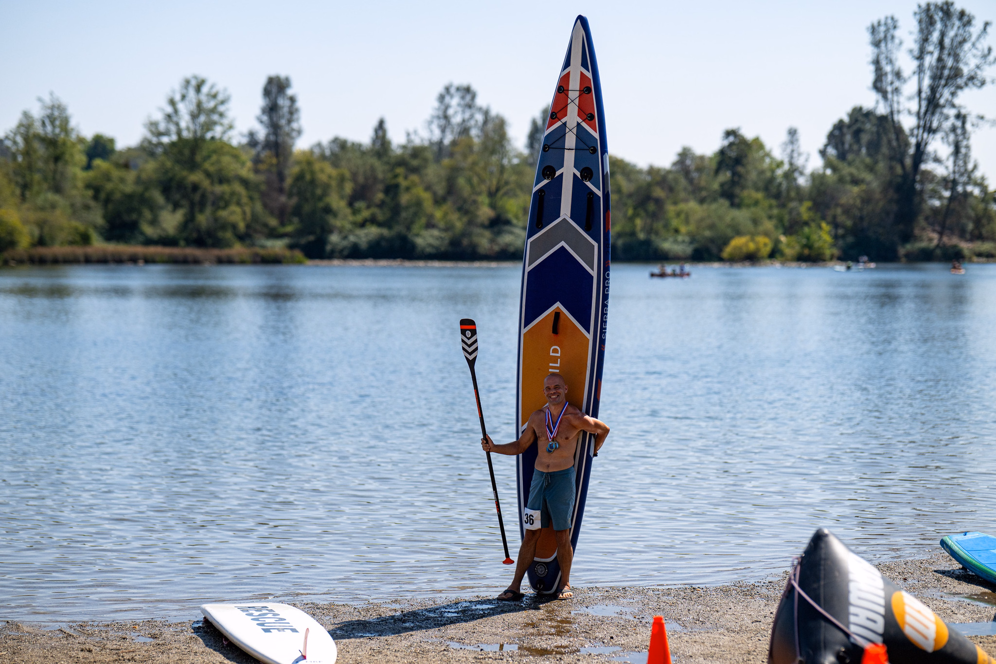 2026 paddlesplash festival at lake natoma: races, relays, festivities, and taking home gold 44 the schedule travels. The single most useful thing i did at paddlesplash was settle in advance what went in and when, rather than deciding it on the day. Nationals spreads the big three across three days rather than three hours, which makes the planning easier and the discipline harder. Paddler standing beside his 14-foot venture wild sierra pro inflatable board stood on end, wearing race medals and bib 36, at lake natoma