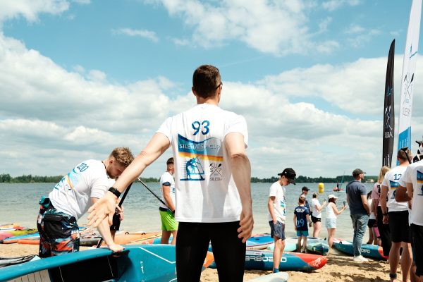 Stand-up paddlers gathered at the start of a sup race event on open water.