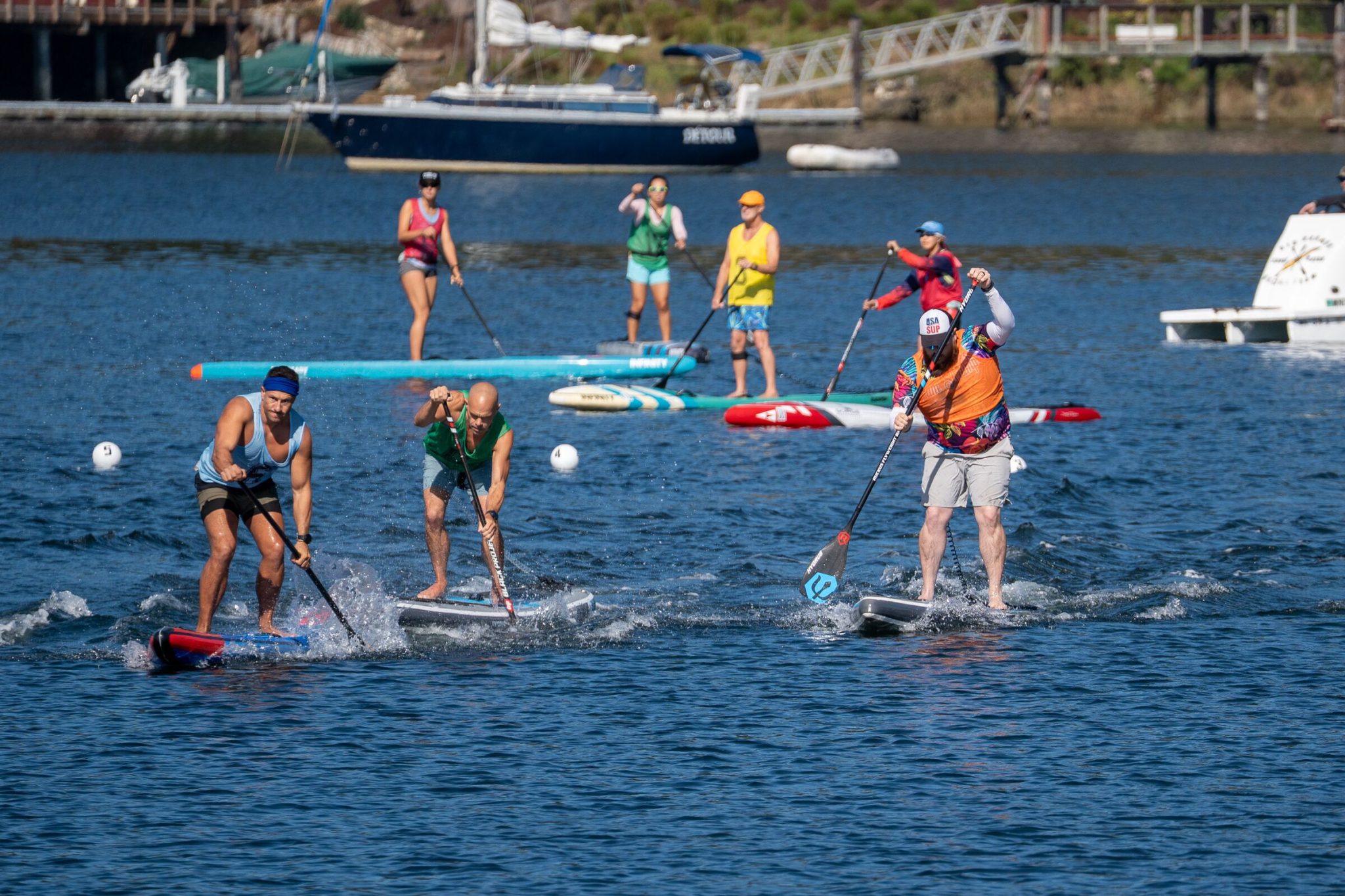 Three paddlers racing side by side on inflatable boards in the men's inflatable sprint final at the 2026 usa sup national championships in gig harbor